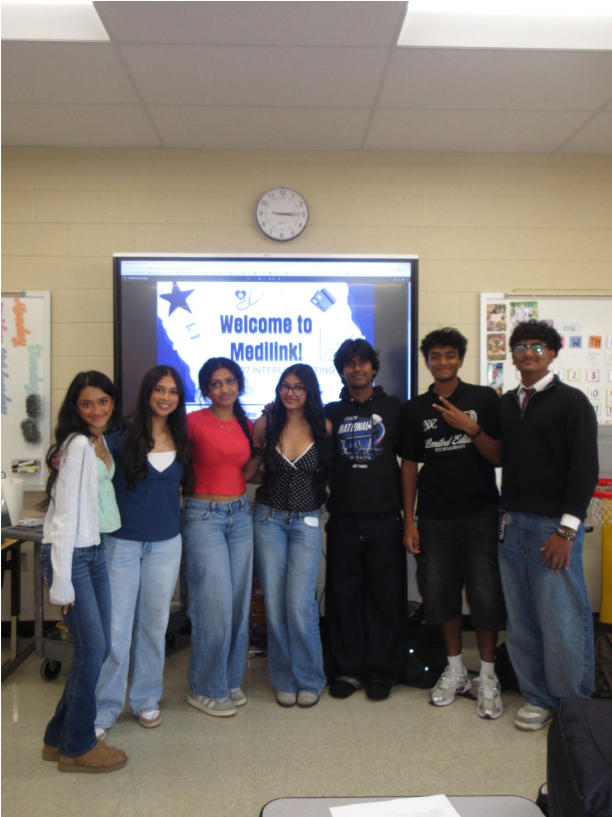 Six Ravenwood High School MediLink members standing in front of a classroom board that reads Welcome to MediLink